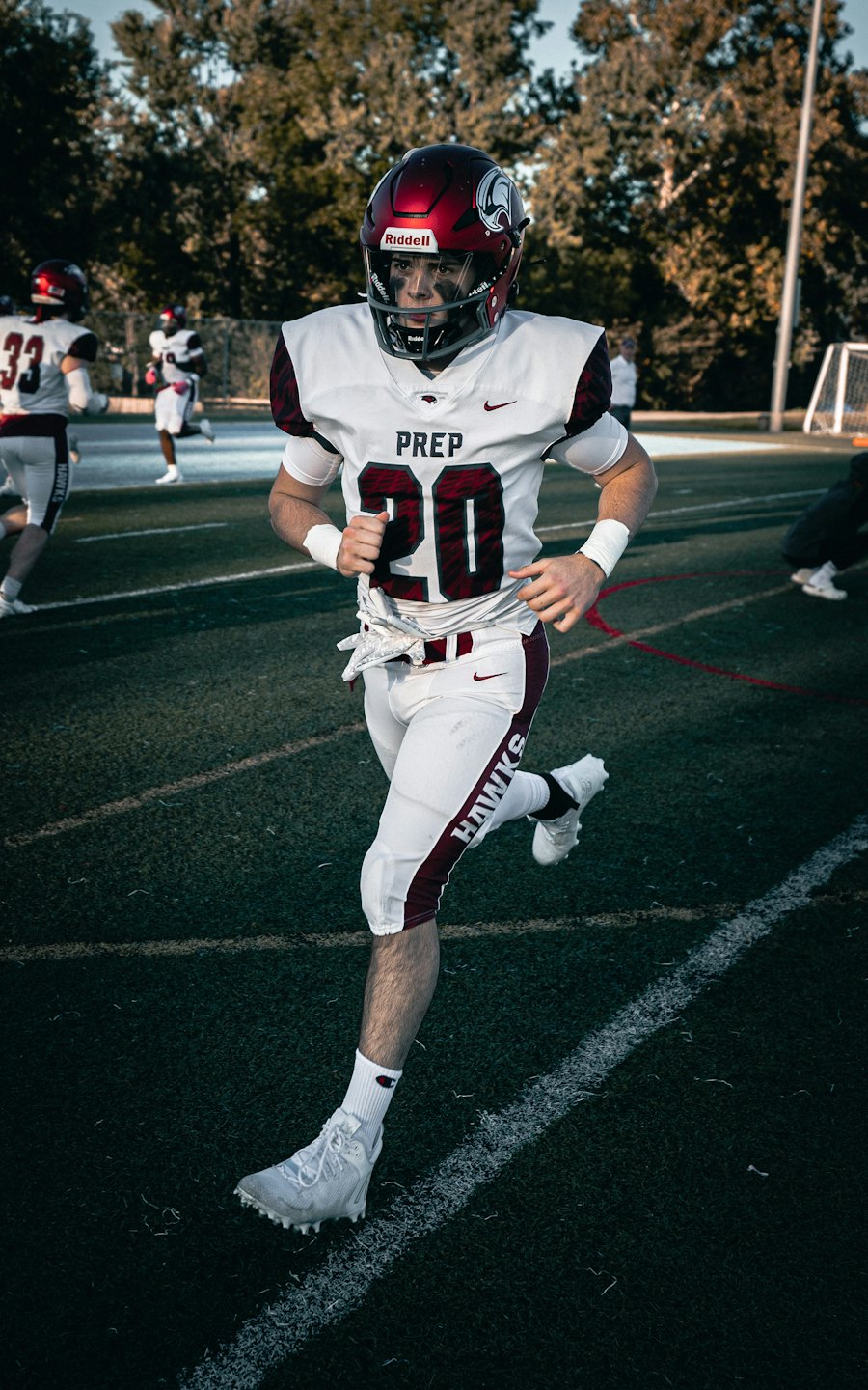 Football player in a maroon uniform running across the field.